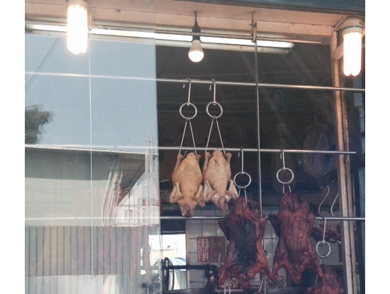 鳥やら豚が吊るされて店頭に