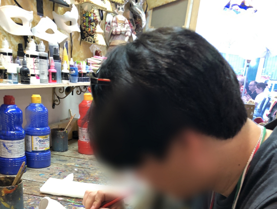 着席してマスクに模様を描いています