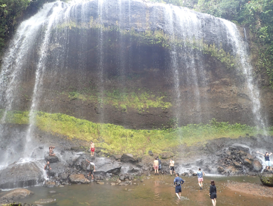 滝で遊ぶ子どもや大人
